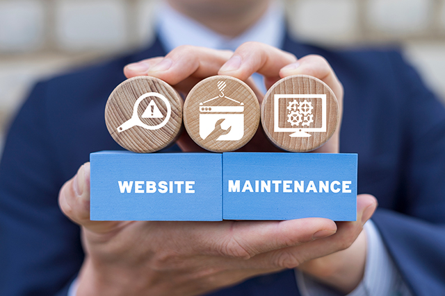 Man holding wooden blocks with the words website maintenance